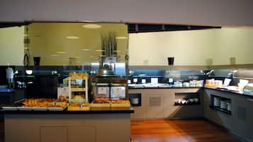 Zona de bufé con diferentes opciones de comida y una estación de café.