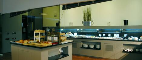 Una barra de buffet con diversos alimentos y una planta en maceta en la encimera.
