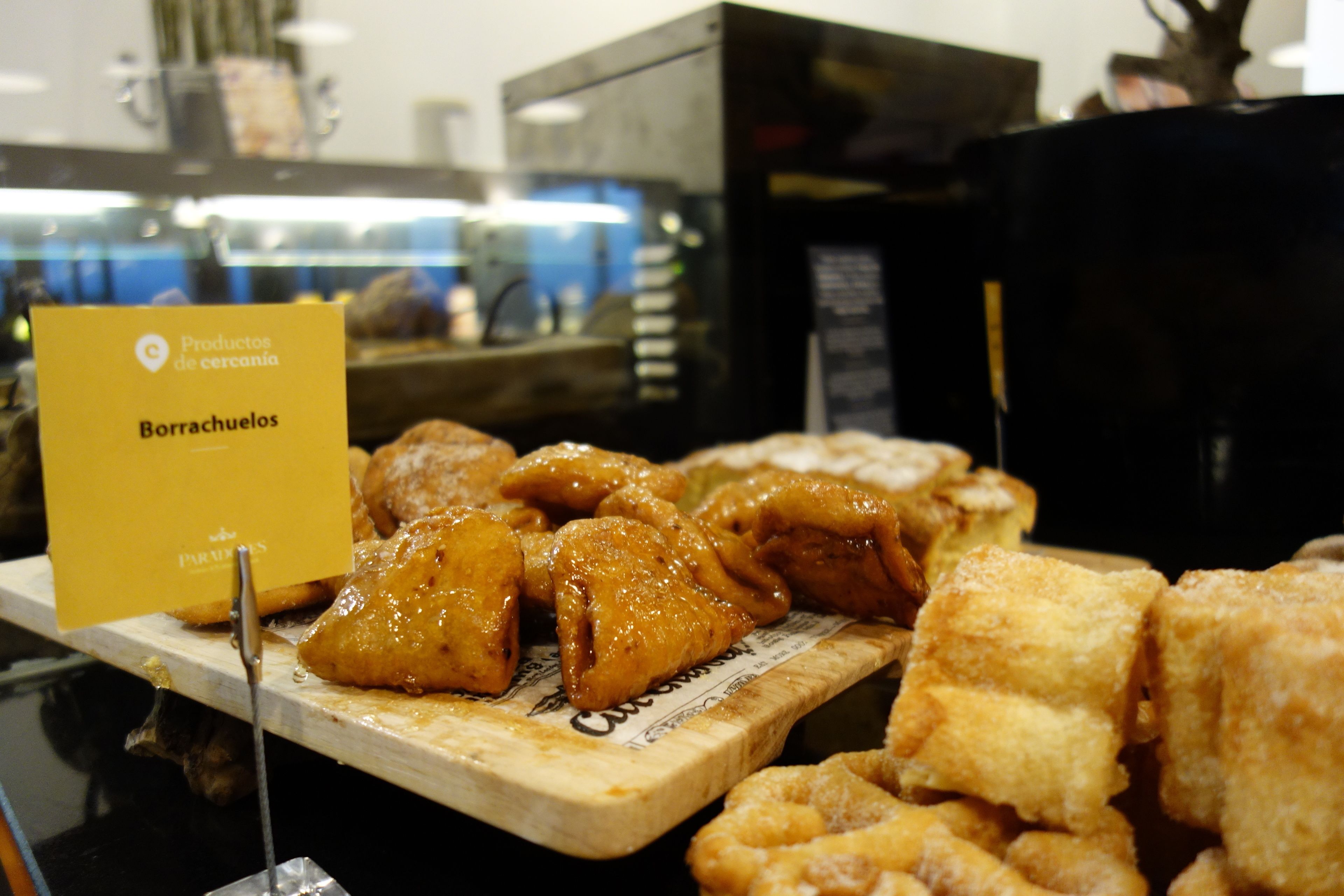 A display of fried chicken wings and pastries in a bakery setting.