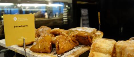 A display of fried chicken wings and pastries in a bakery setting.