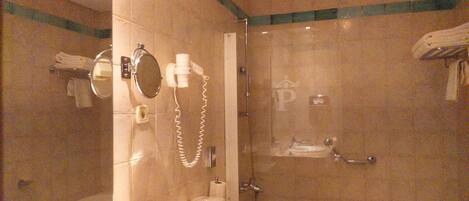 Un baño con ducha envuelta en vidrio, inodoro, lavabo y espejo.