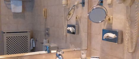 A bathroom with two sinks, a mirror, a telephone, and a towel rack.