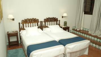 A double bed with a wooden headboard, two bedside tables, and a nightstand.