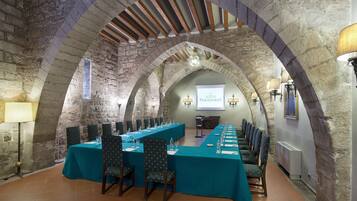 A conference room with a long table, chairs, and a projector screen.