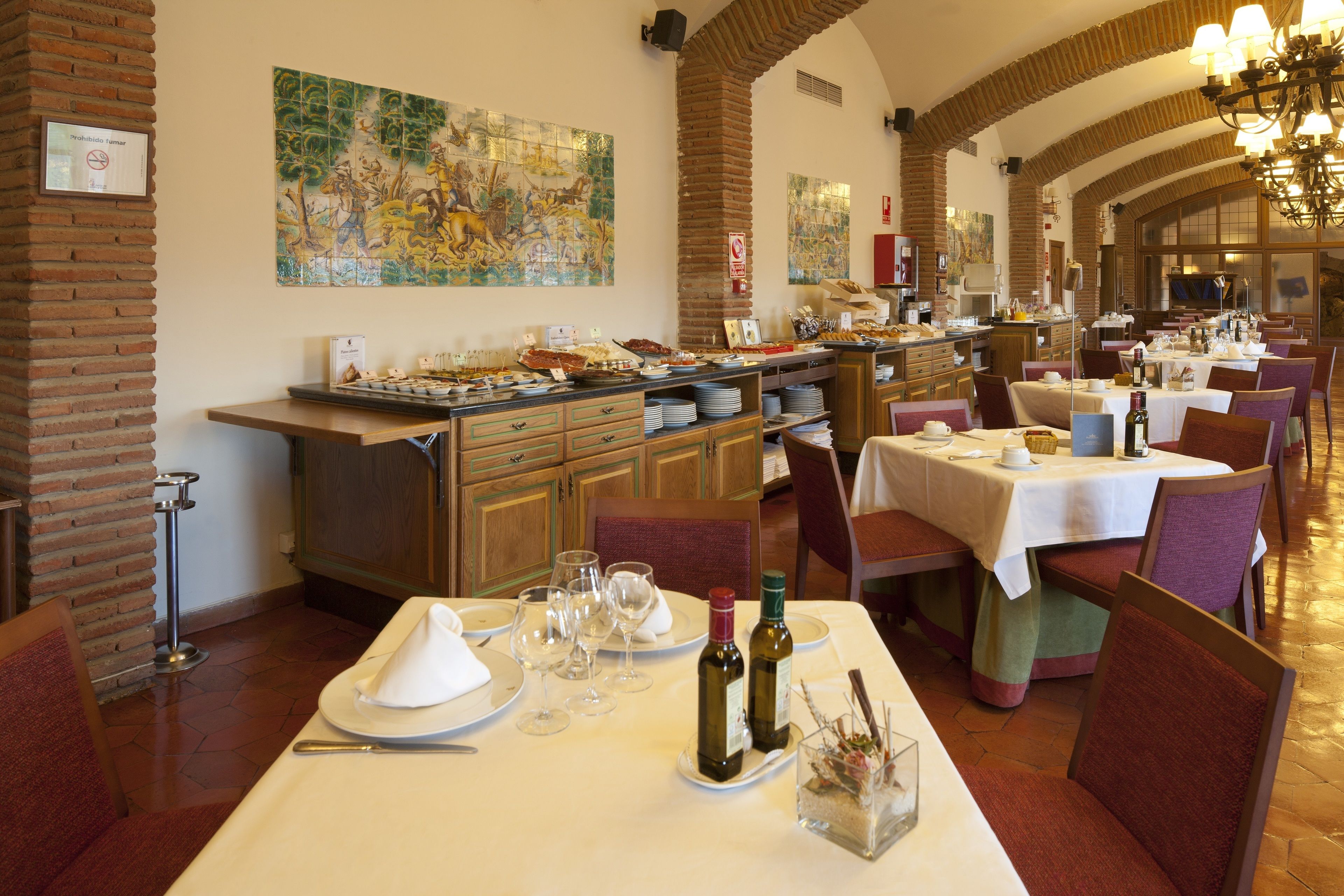 Un restaurante con mesas altas, sillas y una zona de bufé.