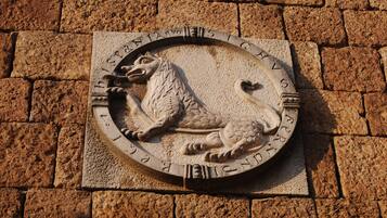 Una placa de piedra con un león y una tortuga, rodeada de inscripciones.