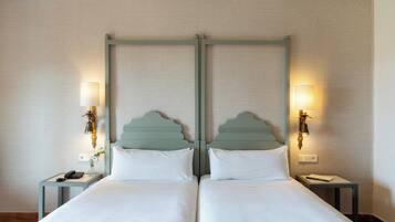A double bed with a wooden headboard, two bedside tables with lamps, and a wall-mounted light fixture.