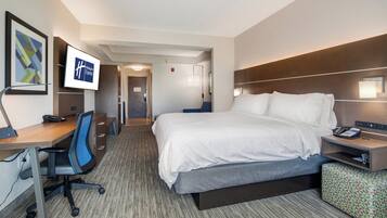A hotel room with a bed, desk, chair, and a flat-screen TV displaying the Holiday Inn Express logo.