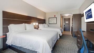 Une chambre d’hôtel avec deux lits, un bureau, une chaise et un téléviseur.