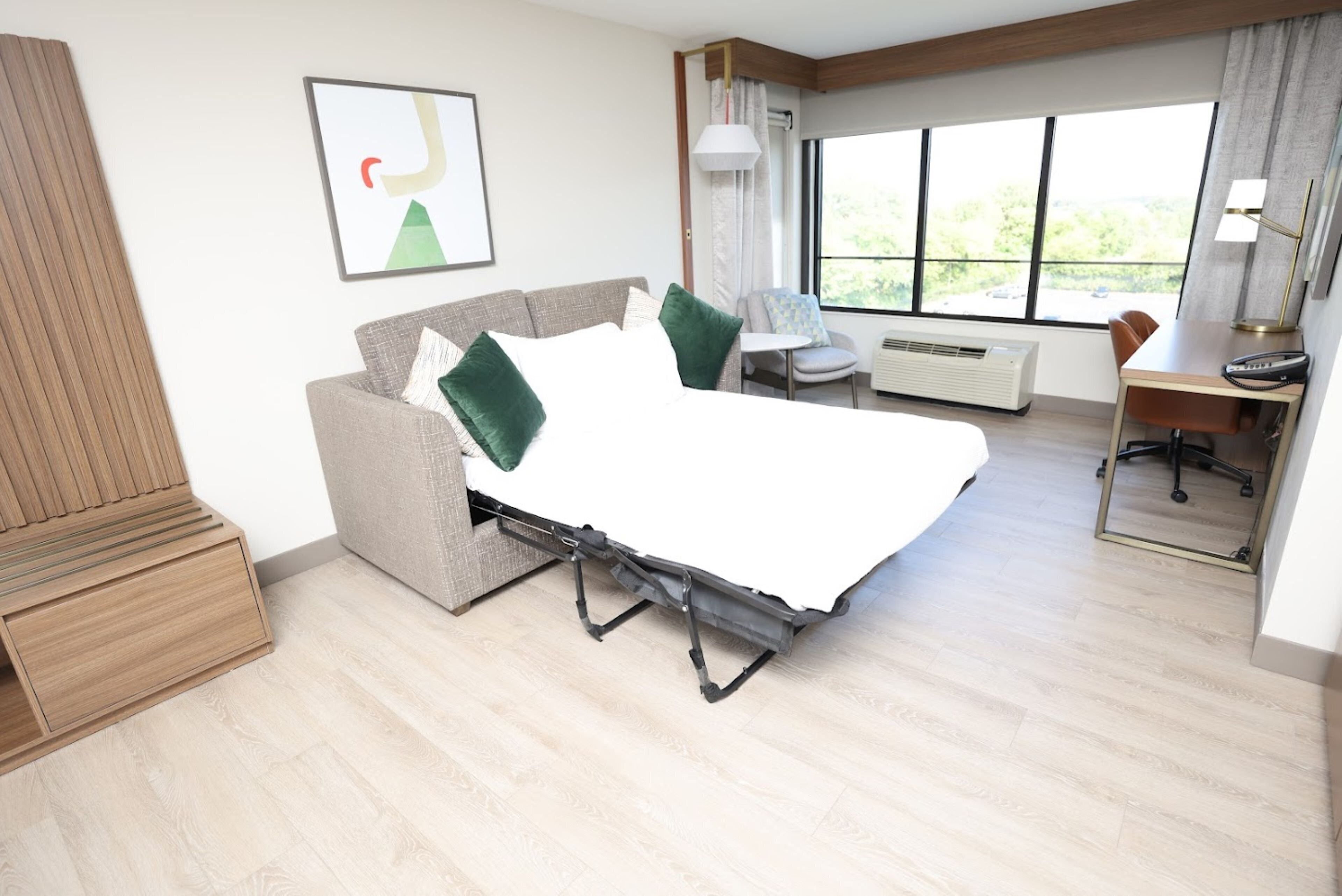 Une chambre d’hôtel moderne, équipée d’un lit, d’un bureau et d’une chaise.