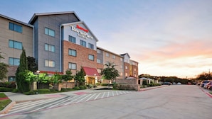 Un hôtel Marriott TownePlace Suites au design moderne, caractérisé par un mélange de façades en brique et en béton, une entrée centrale et un parking.