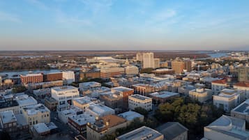 An aerial view of a cityscape with various buildings, roads, and a river in the background.