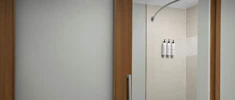 Un baño moderno con bañera, zona de ducha y puerta de madera.