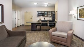 A hotel room with a dining area, a kitchenette, a sofa, and a chair. - Candlewood Suites Athens by IHG (Athens)
