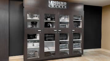 A dark wooden cabinet with multiple glass-fronted compartments, each containing various kitchen appliances like blenders, coffee makers, and toasters.