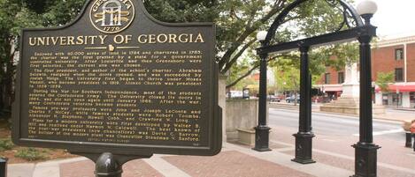A historical marker sign for the University of Georgia, detailing its establishment and notable figures.