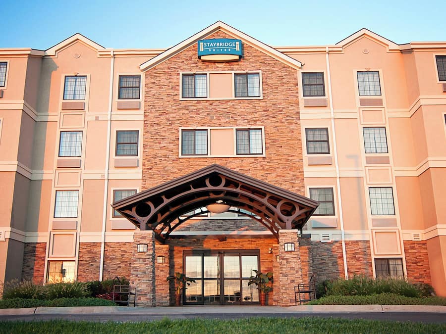 A multi-story hotel with a stone facade, a central entrance with an arch, and multiple windows.