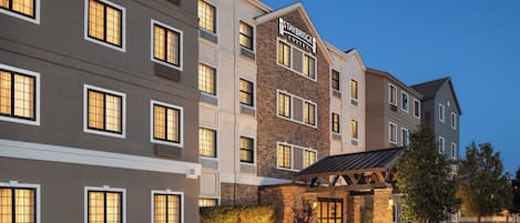 A multi-story hotel with a sign reading 'Staybridge Suites.'