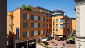 Un hotel de diseño moderno, con un patio que ofrece asientos al aire libre y un coche estacionado cerca.