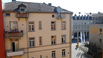 En byggnad med flera våningar, en slät fasad, många fönster och en balkong med blomlådor.