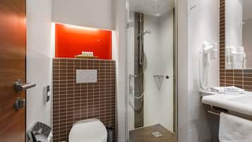 A modern bathroom with a toilet, bidet, and shower.