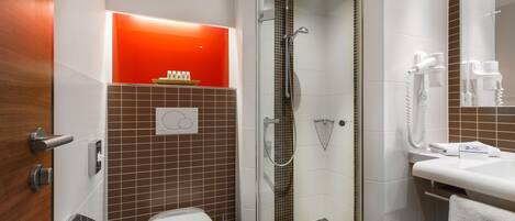 A modern bathroom with a toilet, bidet, and shower.