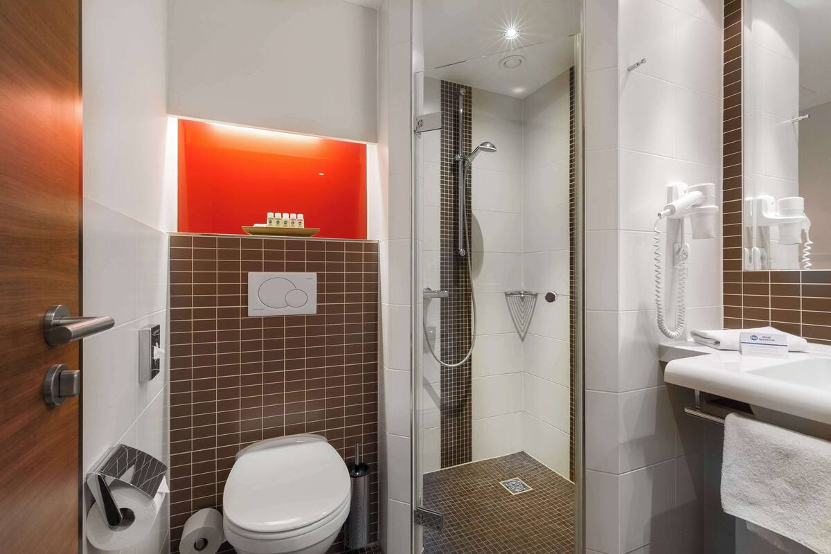 A modern bathroom with a shower, toilet, and sink.