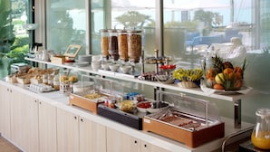 Un buffet proposant une variété de plats et un saladier rempli de fruits.