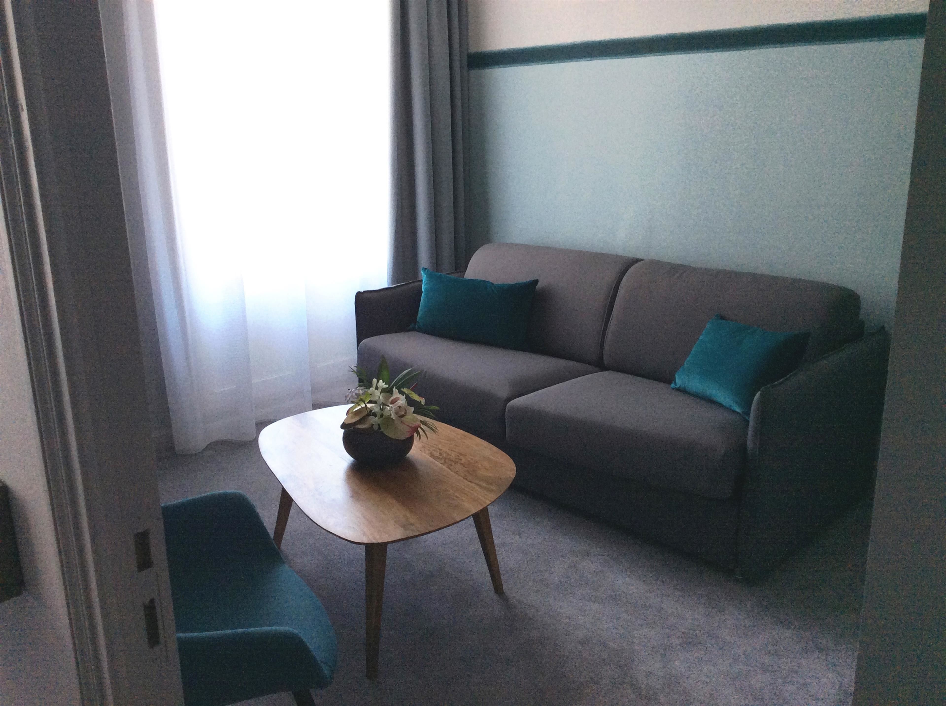 A living room with a sofa, a coffee table, and a chair.