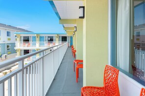 Guests can enjoy the view from this balcony with a row of chairs and a railing overlooking the surrounding buildings.