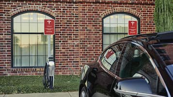 A brick building with two Tesla electric vehicle charging stations.