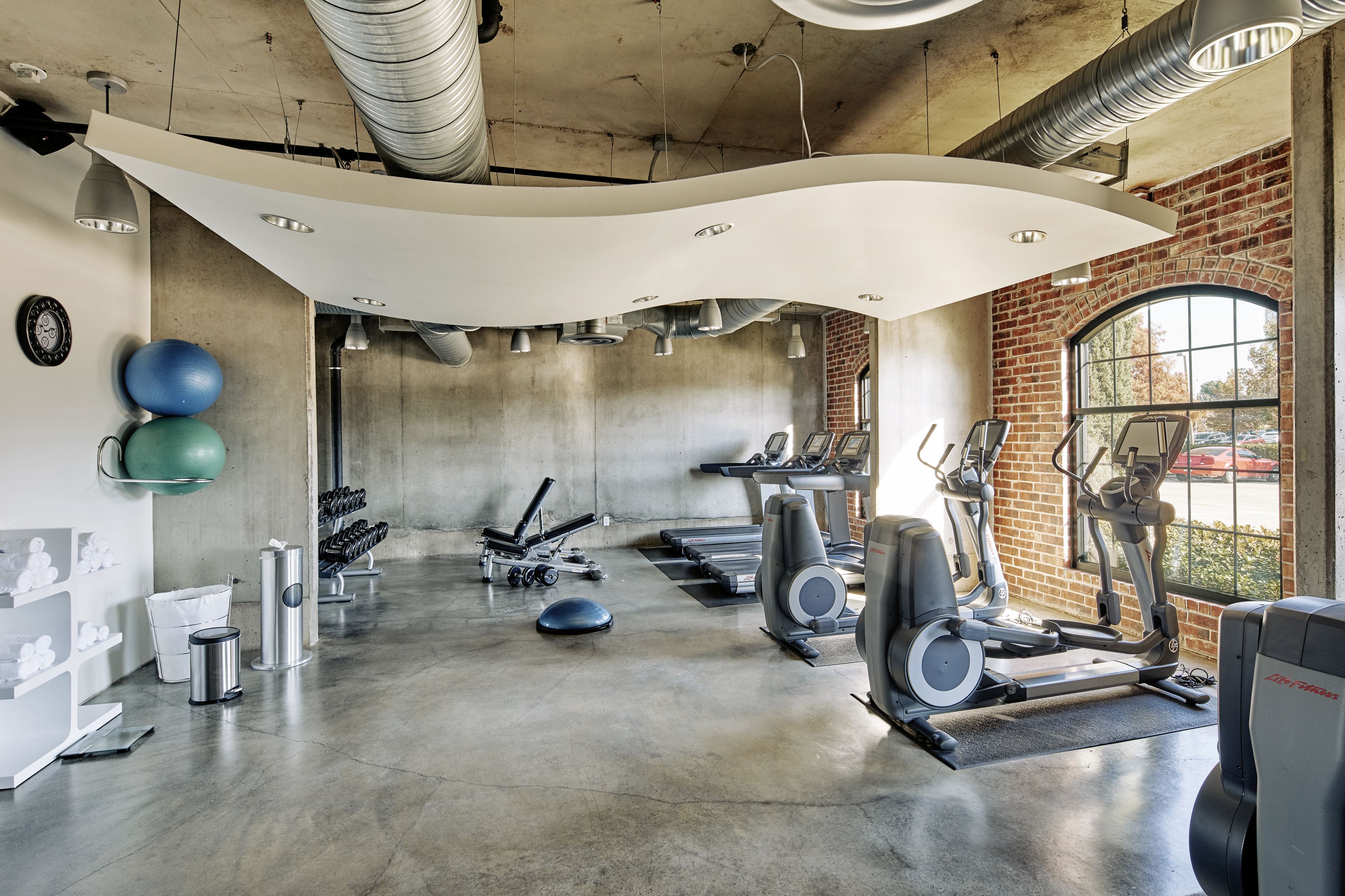 A gym with treadmills, elliptical machines, and free weights.