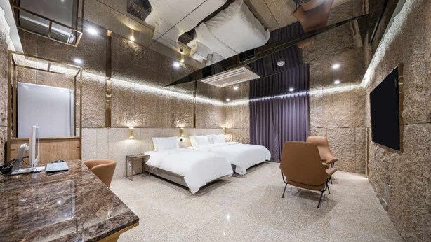 Une chambre d’hôtel moderne avec un grand lit, un bureau et une télévision.