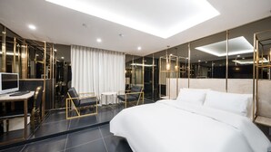 Une chambre d’hôtel moderne dotée d’un grand lit, d’un bureau et d’un coin salon.