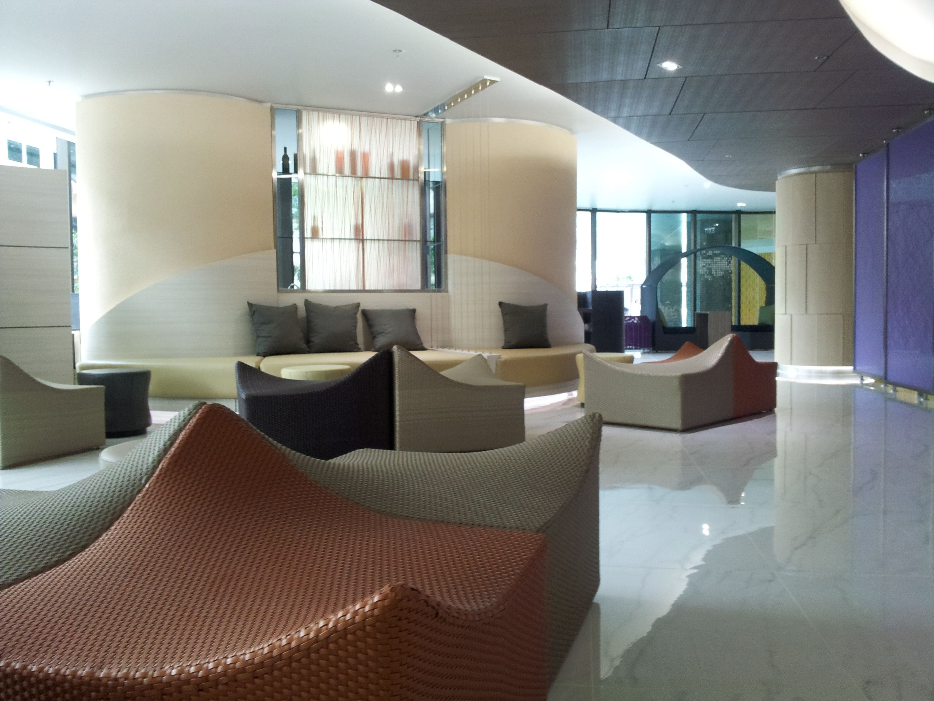 A modern lounge area with curved seating and a large window.