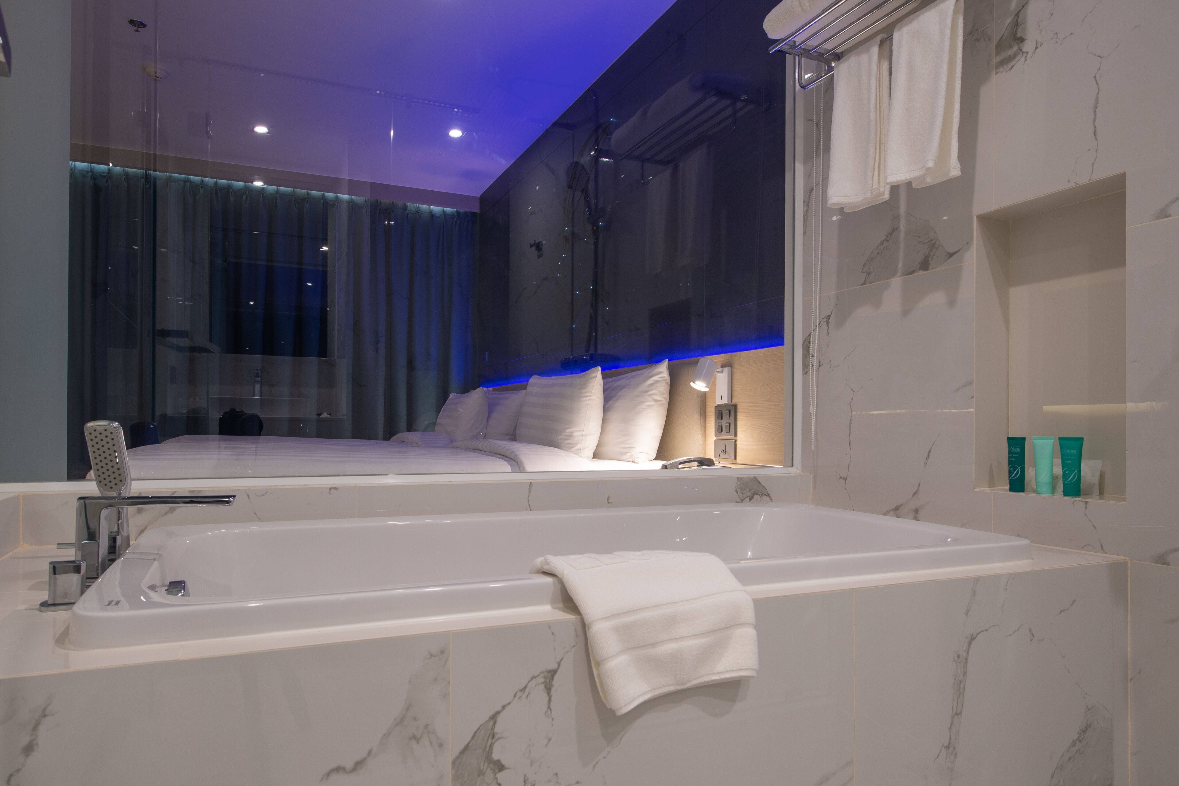 A modern bathroom with a large bathtub, a glass shower enclosure, and a vanity with a mirror.