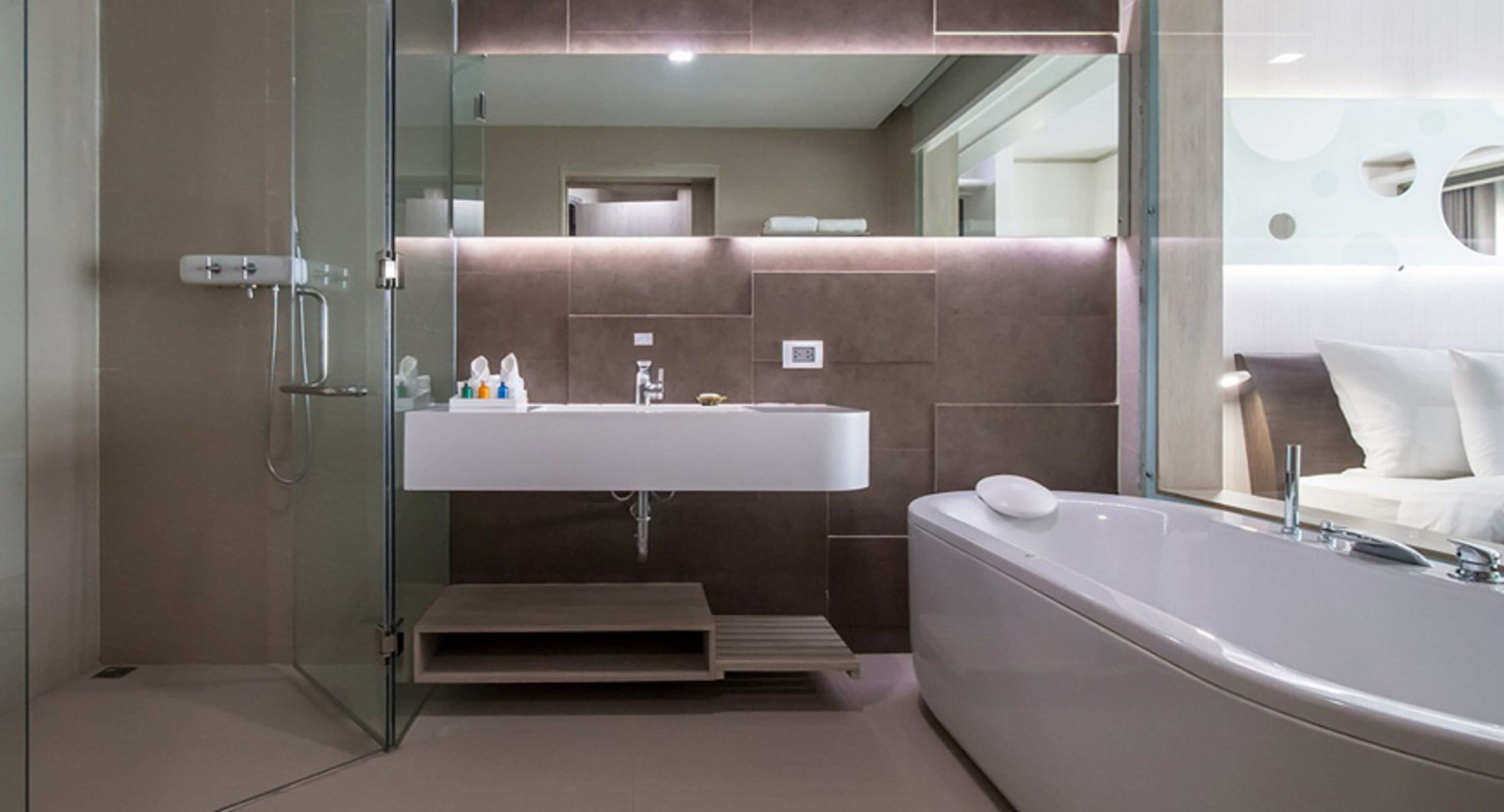 A modern bathroom with a glass-enclosed shower, a large sink, and a freestanding bathtub.