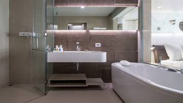 A modern bathroom with a glass-enclosed shower, a large sink, and a freestanding bathtub.