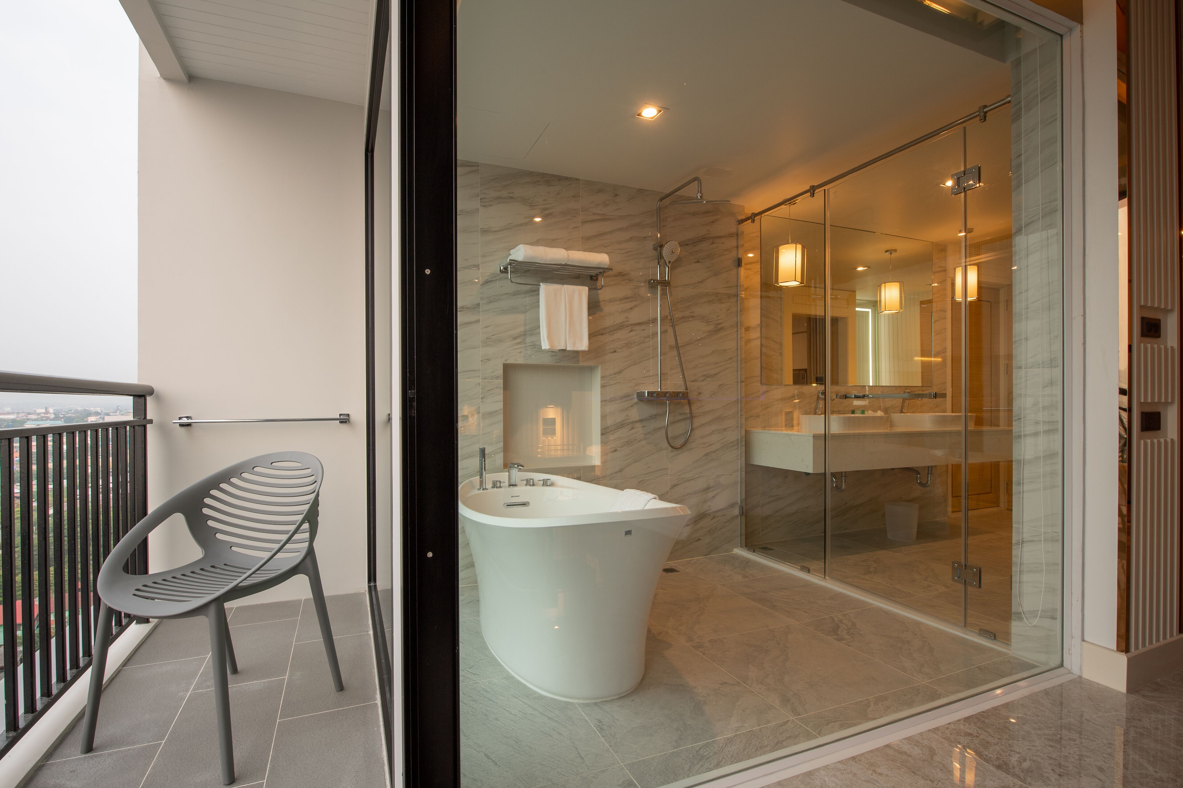 A modern bathroom with a freestanding bathtub, a glass-enclosed shower, and a visible toilet.
