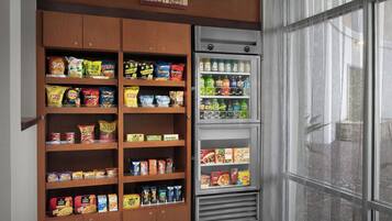 Una màquina expenedora de llaminatures i una estanteria de fusta amb diferents productes envasellats.