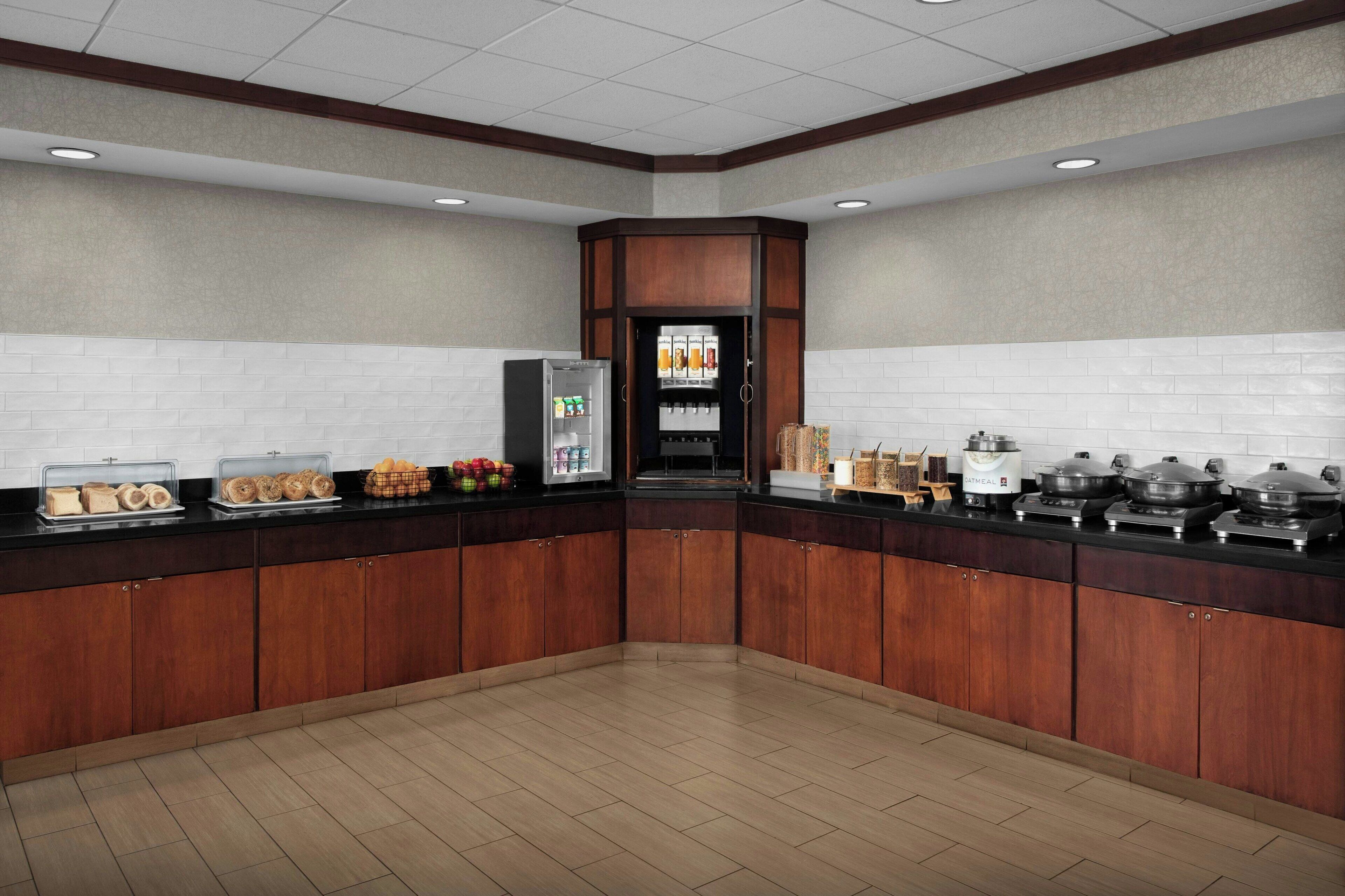 Una cocina moderna con armarios de madera, un refrigerador y una estación de café.
