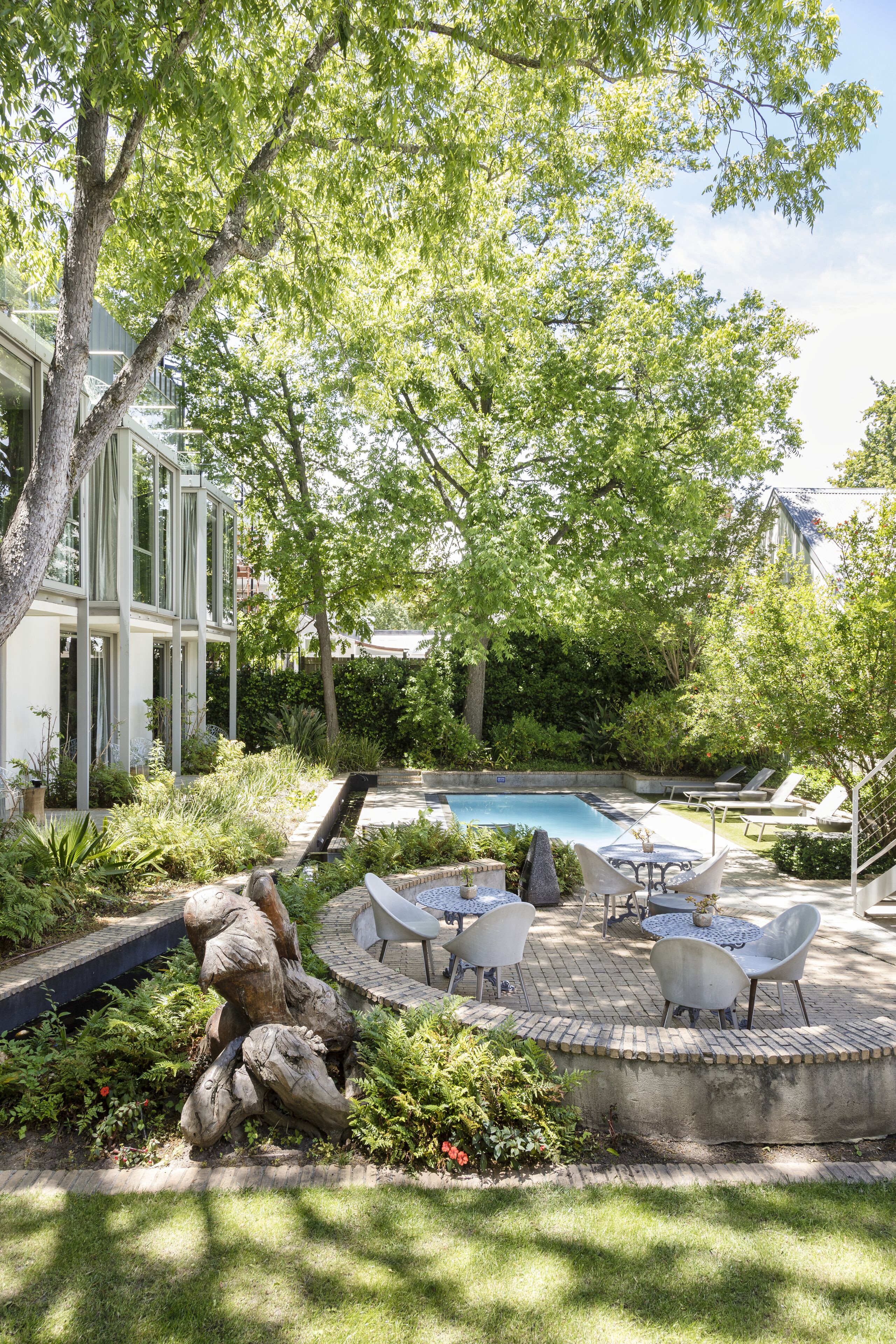 Una piscina al aire libre, sombrillas, sillones reclinables de piscina