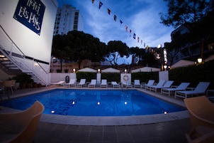 Una piscina al aire libre, sillones reclinables de piscina