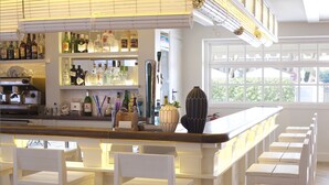 Una zona de bar con sillas blancas, estantes llenos de botellas de licor y un ventanal grande.