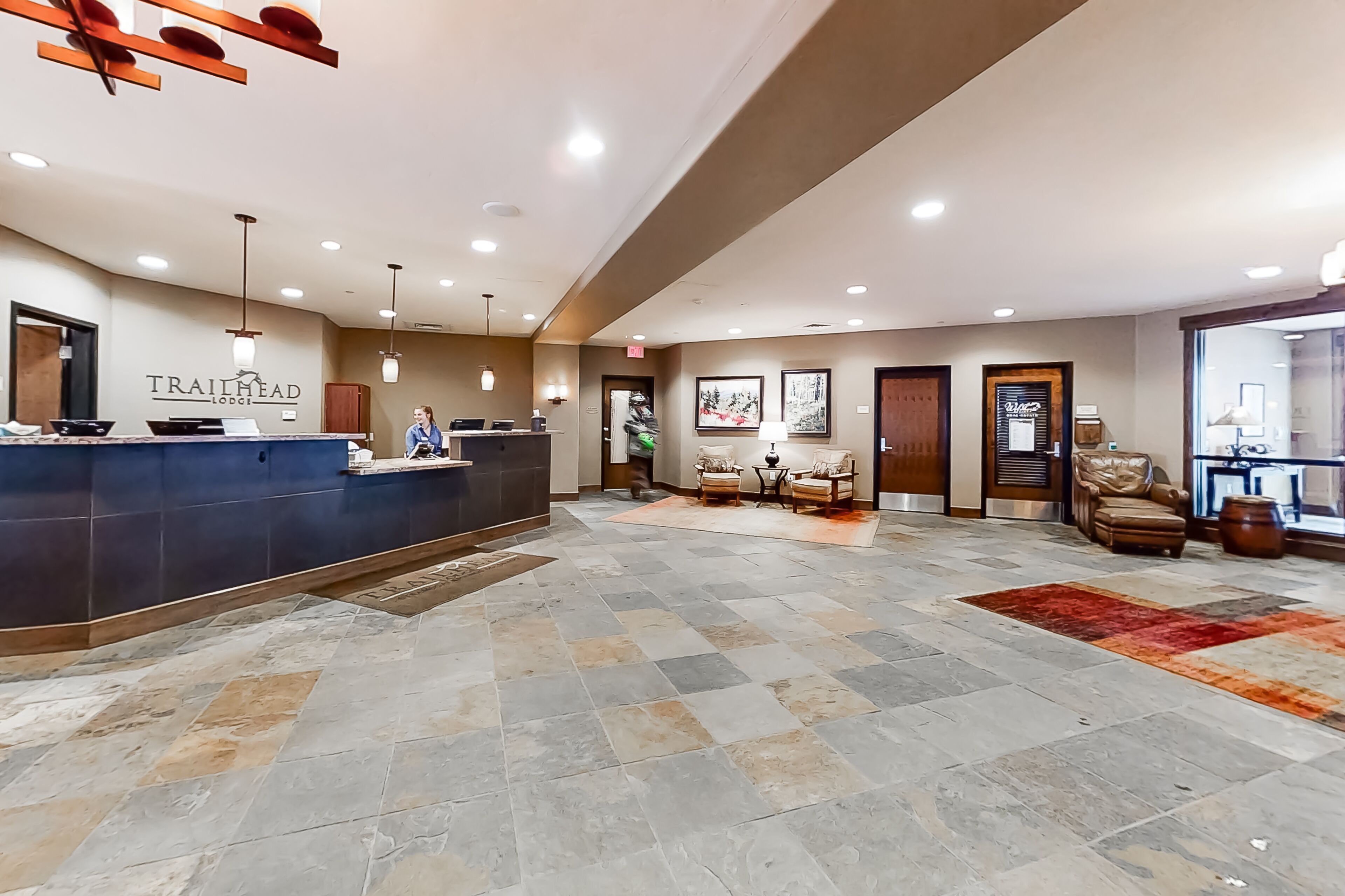 A spacious lobby with a reception desk, seating area, and a large window.
