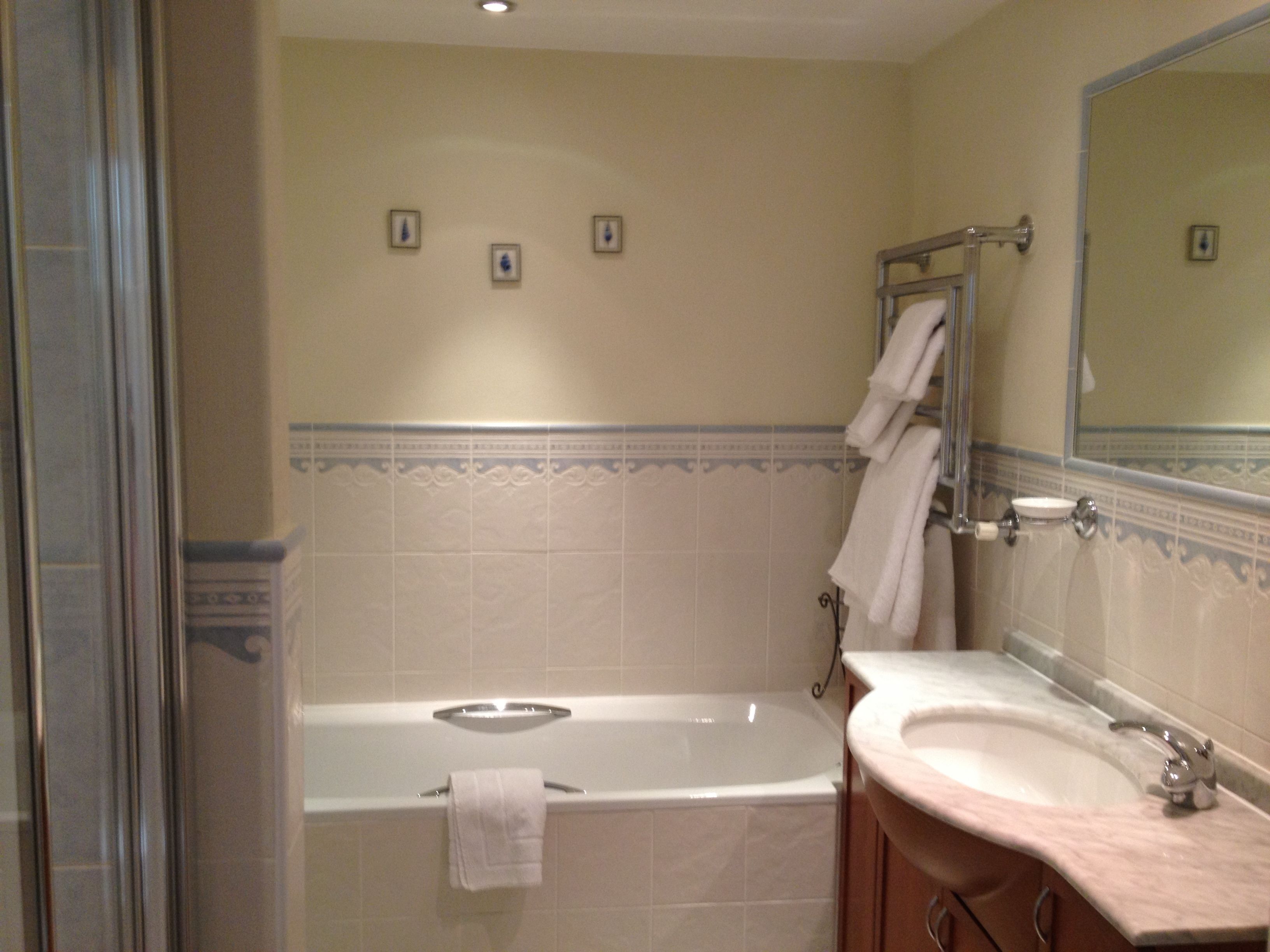 A bathroom with a bathtub, a sink, and a mirror.
