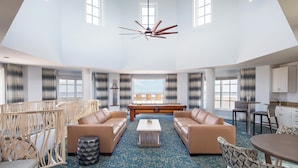 A spacious living area with a high ceiling, a ceiling fan, a pool table, and a view of the outdoors. - The Westin Cape Coral Resort At Marina Village (Cape Coral)