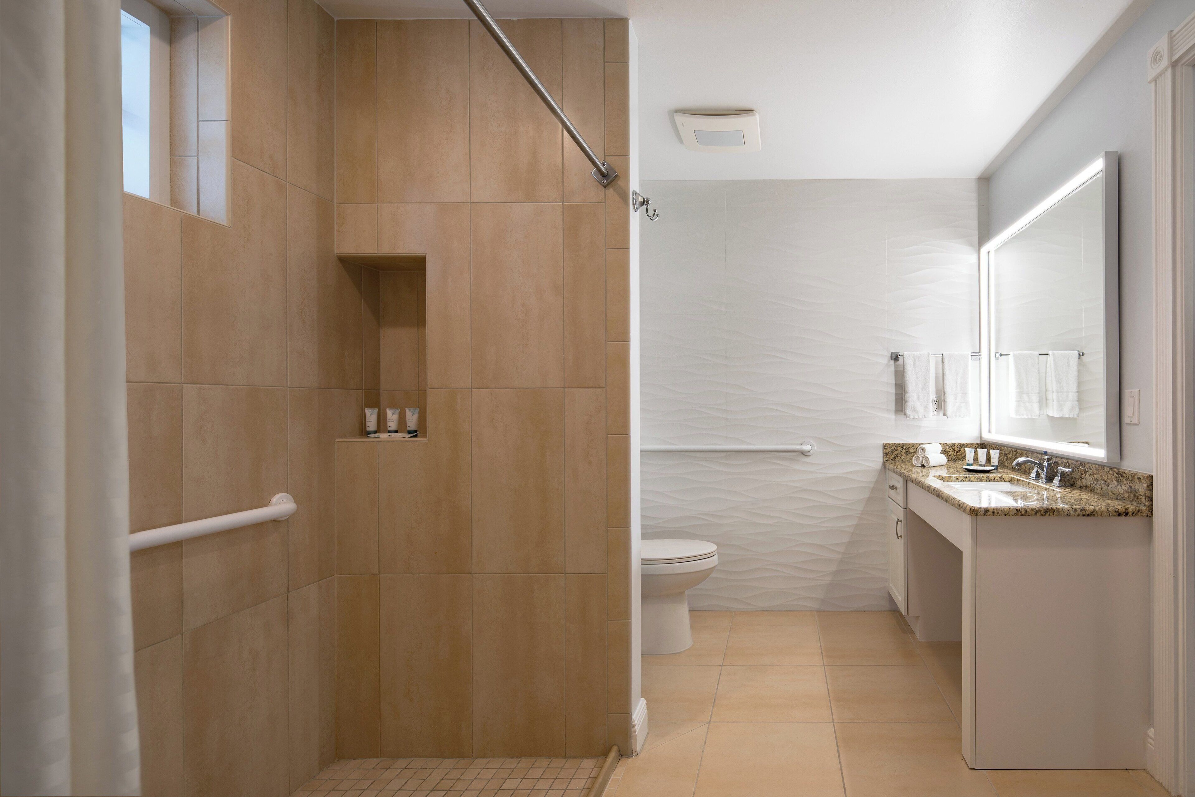 Un baño moderno con ducha, inodoro y tocador.