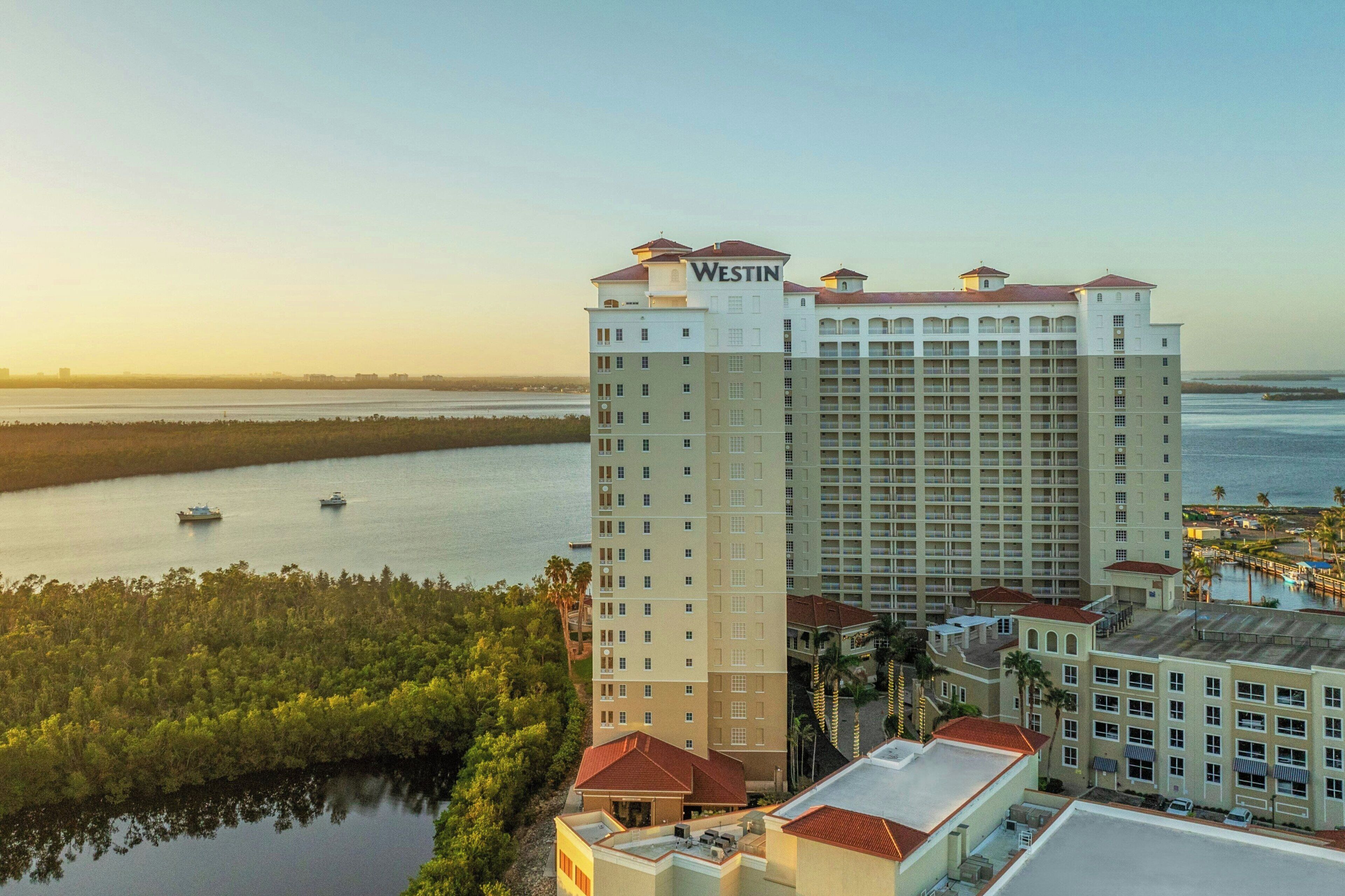 A Westin hotel with a view of the water and a forested area.
