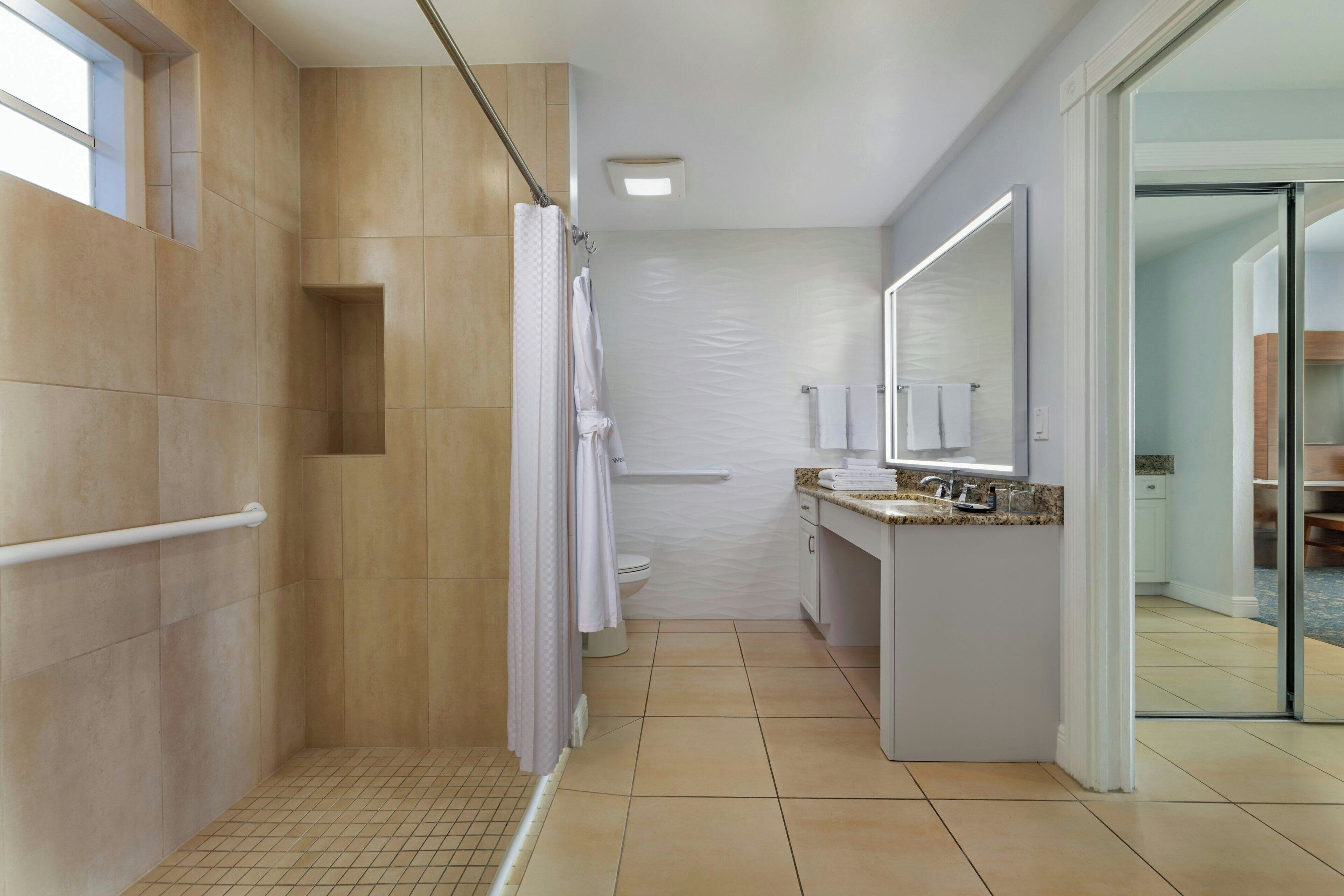 A modern bathroom with a shower, toilet, and sink area.